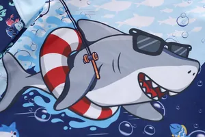Close-up of a cartoon shark print with sunglasses on blue kids' swimwear fabric