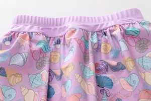 Detail of lavender girl's swimsuit skirt with seashell patterns and elastic waist
