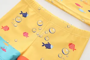 Dettaglio del costume da bagno giallo per bambini con stampe di pesci e vita elastica