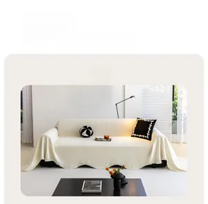 Détail de la housse de canapé en chenille crème avec motif tricoté et franges