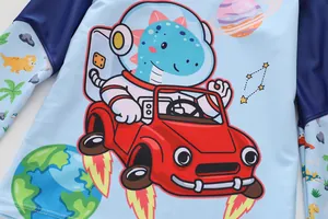 Detail of blue boys swimsuit showing cartoon space dinosaur print and fine stitching