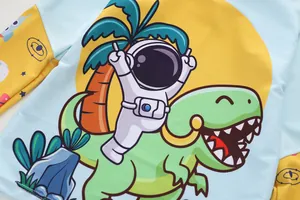 Detail of kids long sleeve swimwear featuring a cartoon astronaut and dinosaur print