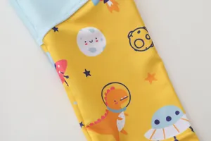 Detail of high-elasticity fabric with colorful space dinosaur print for kids swimwear