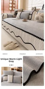 Detail of light gray chenille sofa cover featuring scalloped edges and textured fabric