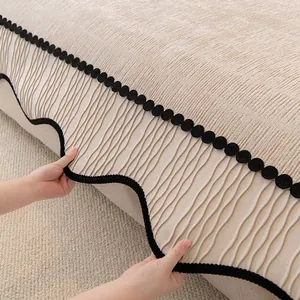 Beige chenille sofa cover featuring irregular black wavy edges and ribbed texture