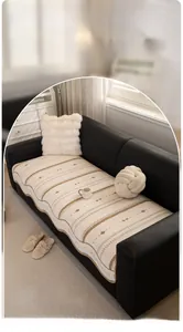 Detailed texture of cream-style sofa cover with brown geometric patterns on black leather
