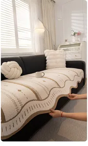 Macro shot of cream sofa cover with wavy edges and brown trim on black leather couch