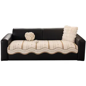 Minimalist beige sofa cover with brown stripes and decorative wavy edges on leather sofa