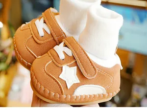 Close-up of brown baby walking shoes with star pattern and soft rubber soles