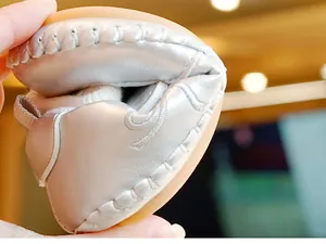 Detail van de flexibele rubberen zool en het zachte zilveren leer van deze babyschoenen