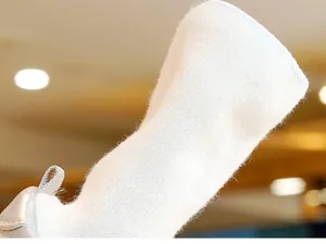 Detailopname van zachte witte gebreide babyschoentjes met pluizige textuur en hiellusje