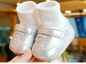 Detail van zilveren babyloopschoentjes met klittenbandsluiting en libelborduurwerk