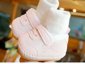 Detail van roze baby loopschoen met een schattige leren strik en zachte gebreide boord