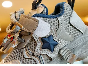 Detailopname van ademende baby sneakers met stervormige decoratie en klittenband