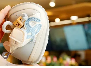 Dettaglio di scarpe primi passi in rete traspirante, pelle grigia e perla decorativa M