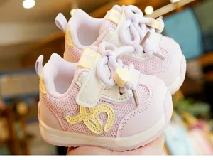 Dettaglio scarpe bimbi rosa e bianche con rete traspirante e chiusura a strappo