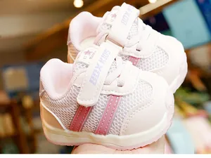 Detail showing pink and white toddler shoes with breathable mesh and velcro closure