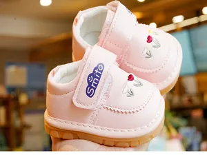 Detail of pink baby shoes with tulip flower embroidery and non-slip rubber soles