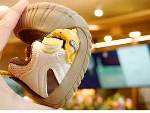 Gros plan de chaussures de marche bébé montrant la semelle en caoutchouc souple et flexible