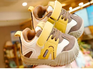 Détail de chaussure de marche bébé en mesh jaune avec velcro et embout de protection