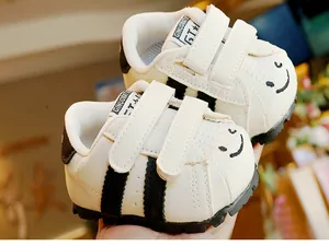 Dettaglio scarpe primi passi per neonati con punta a conchiglia, smiley e suola antiscivolo