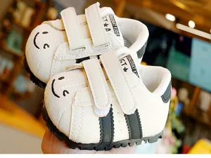 Dettaglio di scarpe primi passi per neonati con doppio velcro e simpatico viso sorridente