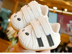 Detail of white infant walking shoes with cartoon bear embroidery and hook-and-loop straps