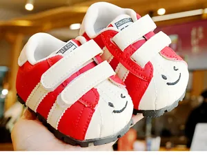 Dettaglio scarpe rosse per neonati con doppia chiusura a strappo e ricamo a fumetti
