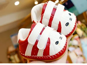 Detail of red and white baby walking shoes with cute dog embroidery and Velcro straps