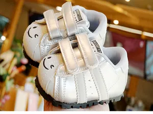 Dettaglio delle scarpe primi passi bianco perla con faccina e suola antiscivolo