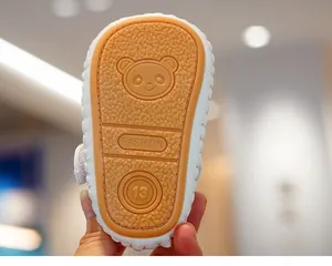 Detail of white baby walking shoe featuring a non-slip rubber sole with panda pattern