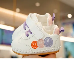Close-up of baby walking shoe with non-slip sole, velcro closure, and smiley face patches