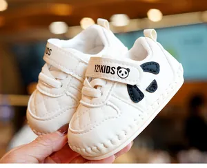 Macro shot of white baby walking shoe with panda motif and quilted faux leather finish