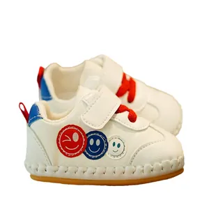 White leather baby walking shoes with colorful smiley patches and anti-slip rubber soles