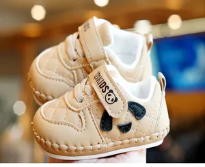 Detailed close-up of soft-sole baby shoes with khaki faux leather and panda motif