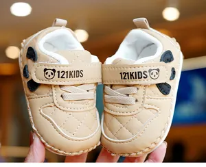 Close-up of beige infant walker shoes featuring quilted pattern and panda ear details