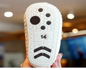 Close-up of white soft baby shoe sole with black anti-slip dots and size number 14