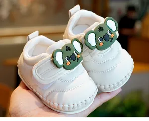 Detail of baby walking shoes with green koala cartoon decor and hook-and-loop strap
