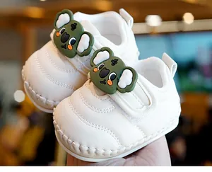 Detail showing the white baby walking shoe with a 3D cute koala mascot and soft leather texture