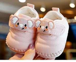 Detail of pink baby walking shoes with velcro straps and a 3D cartoon koala patch