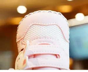 Detail van roze baby loopschoen met konijnenoren en ademend mesh materiaal