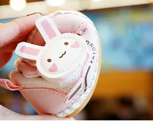 Close-up van roze baby-loopschoentjes met zacht mesh en een schattige witte konijnenflap