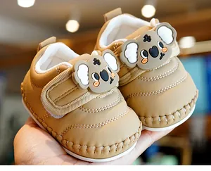 Close-up of soft khaki baby shoes with cute koala silicone patch and velcro closure