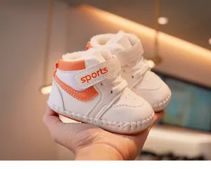 Detail of warm white fleece lining and orange velcro closure on baby winter walking shoes