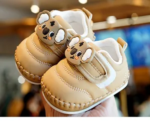 Close-up of khaki baby shoes with cute koala design and handmade stitching details