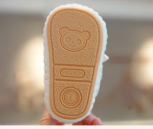 Detailed view of non-slip rubber sole with cute bear pattern and traction texture for baby shoes