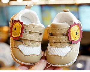 Detail van baby loopschoenen met leeuw ontwerp, mesh bovenwerk en zachte antislipzool