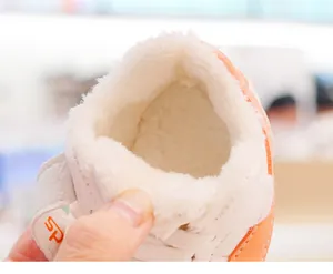 Detailaufnahme des dicken Plüschfutters und Klettverschlusses am weißen Babyschuh