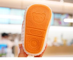 Detail der Babyschuhsohle mit rutschfestem Pandamuster und orangener Gummistruktur