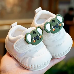Soft-soled infant walking shoes in off-white with cute green koala and velcro straps
